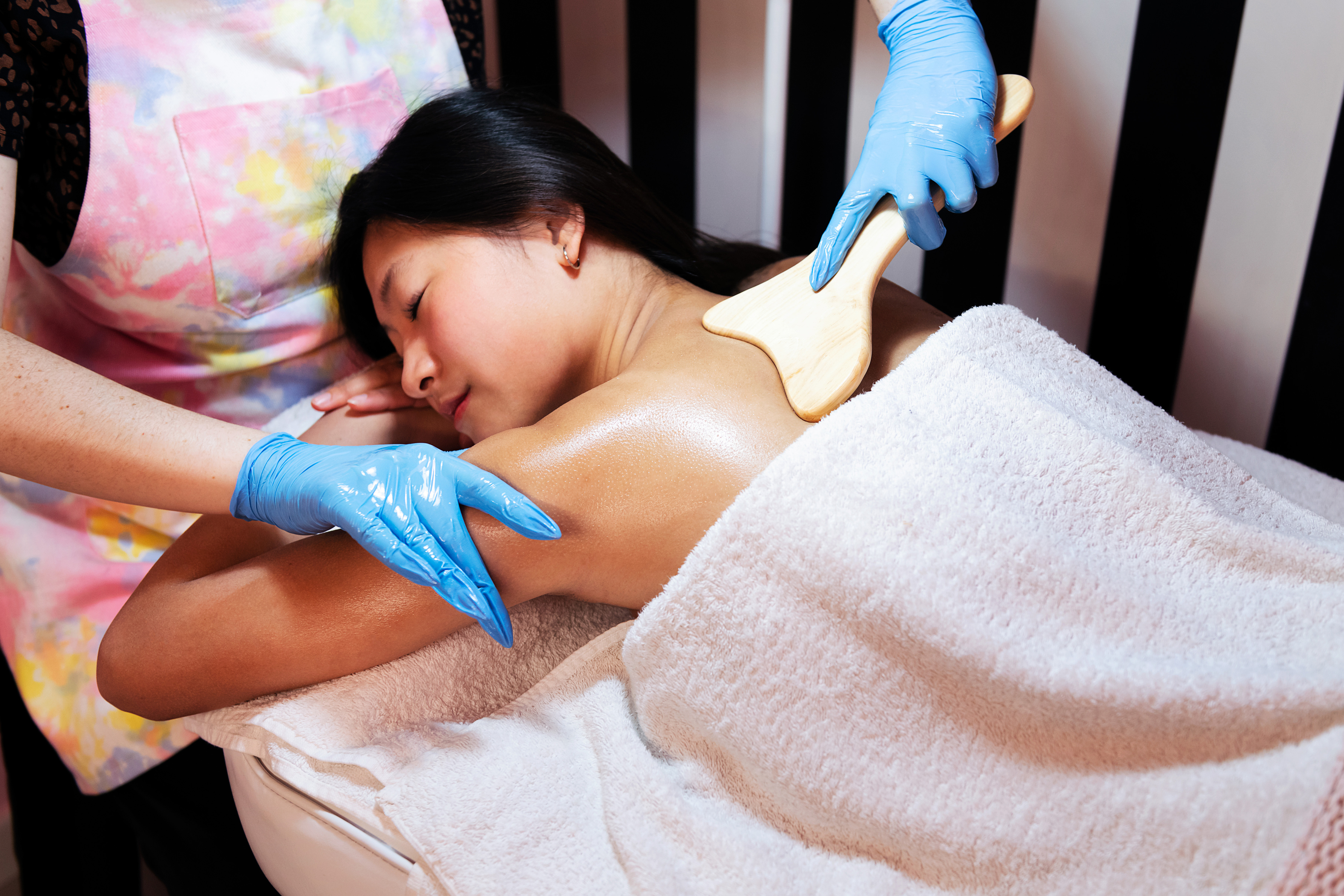 woman receiving a massage with a wooden spatula